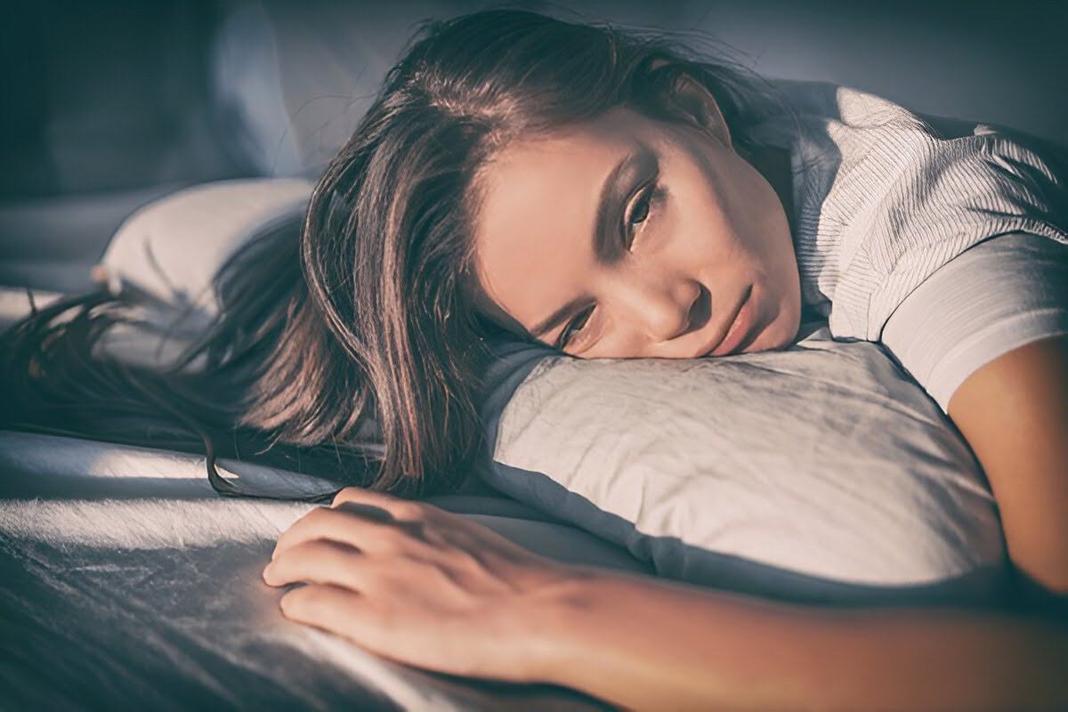 Tired woman lying in bed can’t sleep