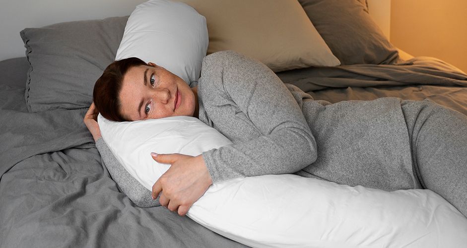 A woman using a body pillow.
