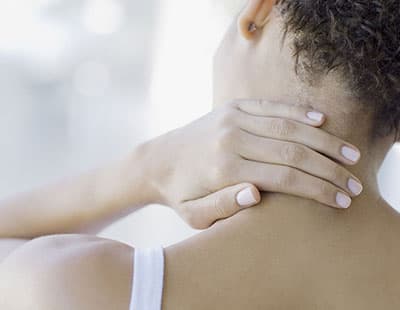 A woman keeping a plan on the back of her neck in pain