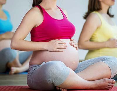 Pregnant women sitting with crossed legs and exercising