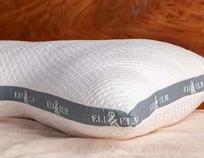 A white pillow by Eli & Elm placed on a white surface