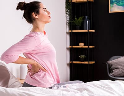 A woman waking up with severe back pain