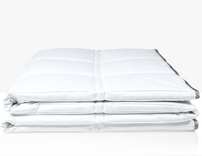A white weighted comforter by Eli & Elm kept folded