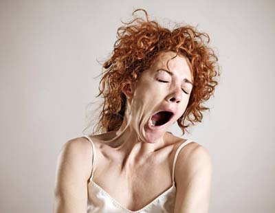 A red-haired woman yawning