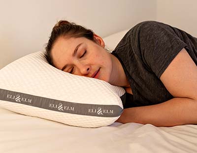 A woman sleeping comfortably on her side with a side sleeper pillow