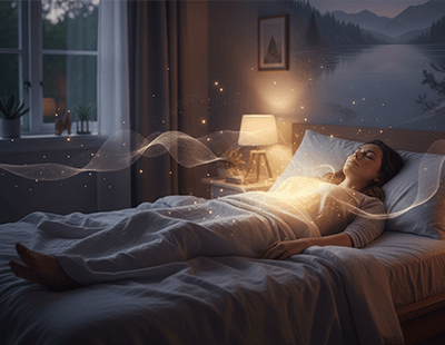 A woman asleep in bed, with a gentle glow of light creating a serene atmosphere