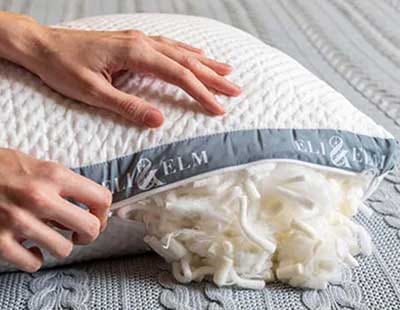 A person’s hand unzipping the adjustable latex pillow by Eli & Elm