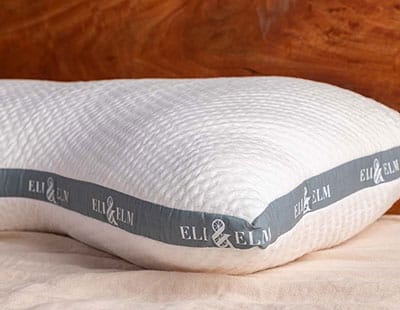 A white pillow by Eli & Elm placed on a white surface