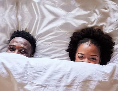 a couple in bed under a weighted blanket