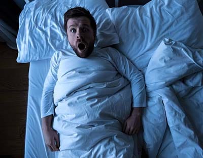 A man waking up in shock