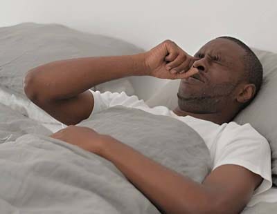 A man unable to sleep due to nighttime allergies