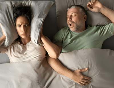 A woman unable to sleep due to his spouse's snoring noise