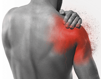 A man holding his shoulder, indicating pain or discomfort.