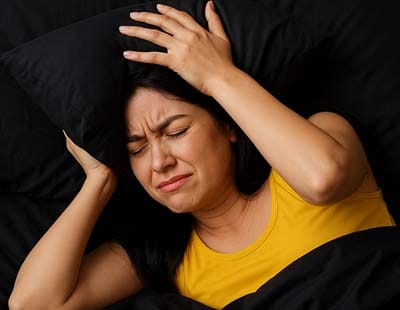 A woman in distress experiencing restlessness while trying to sleep