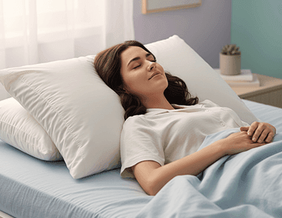 A woman sleeping in peace on her back with a pillow elevating her head