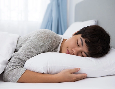 A woman sleeping peacefully with her head resting on a comfortable pillow.