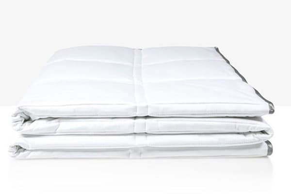 A white weighted comforter by Eli & Elm kept folded