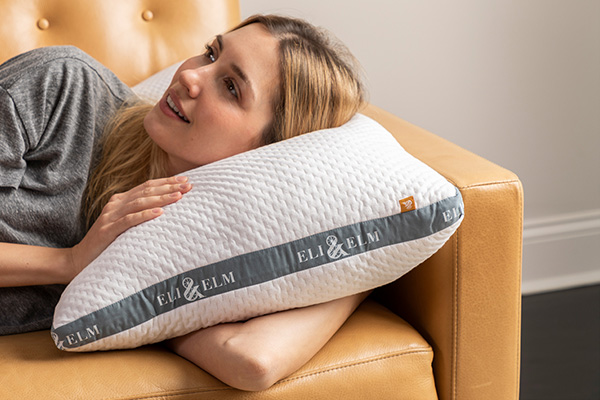 A woman resting her head on a pillow on a couch