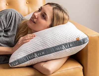 A woman resting her head on a pillow on a couch