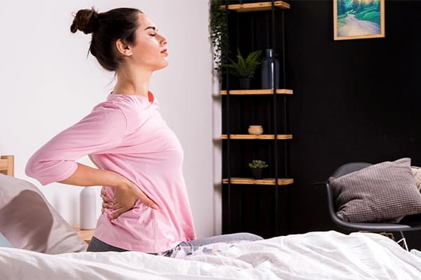A woman waking up with severe back pain