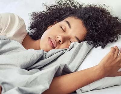 A woman sleeping, resting on a white pillow