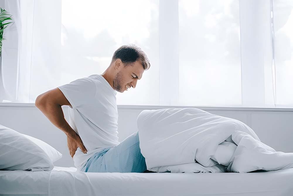 A man agonizing in his lower pain after waking up