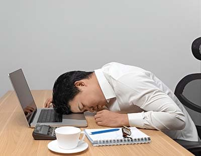 A man falling asleep on his laptop while working