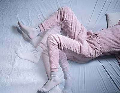 A shot of a woman’s lower abdomen and legs showcasing restless legs syndrome acting up while sleeping