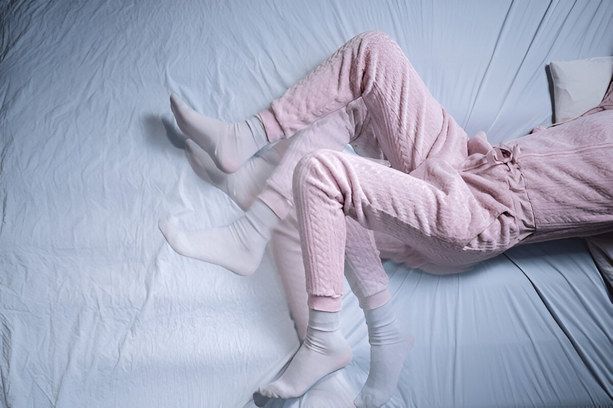 A shot of a woman’s lower abdomen and legs showcasing restless legs syndrome acting up while sleeping