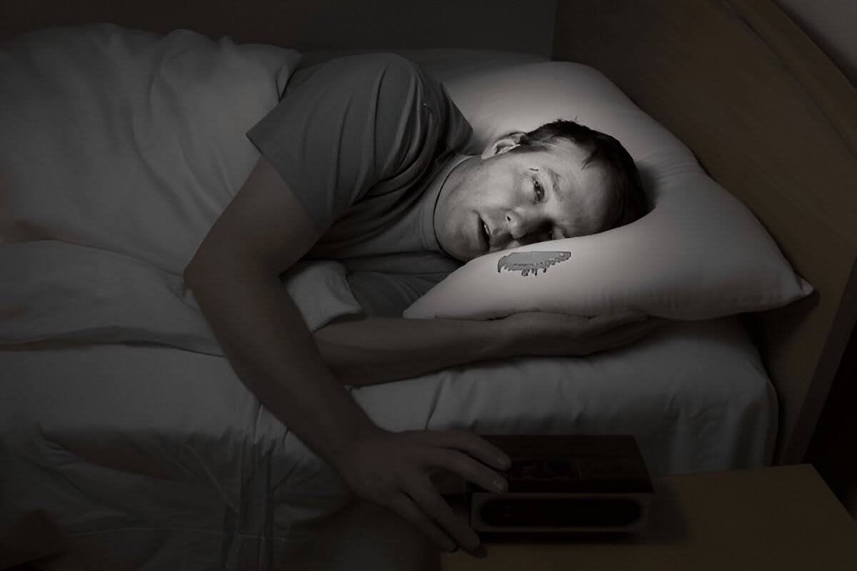 A man unable to sleep due to high humidity in the bedroom