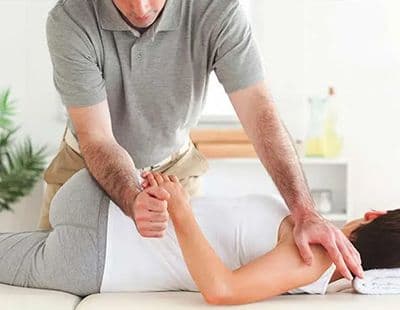 A chiropractor performing a chiropractic adjustment to a pregnant woman.