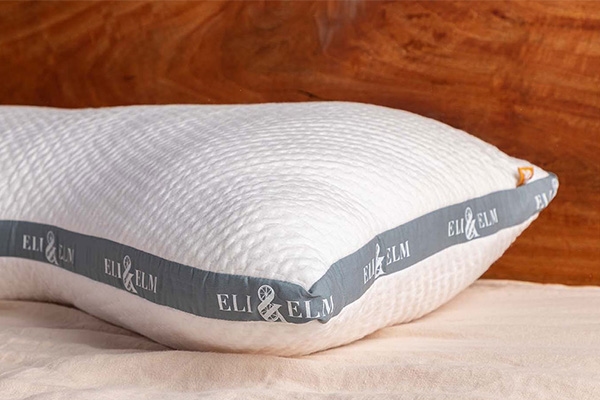 A white pillow by Eli & Elm placed on a white surface