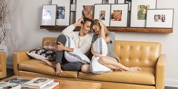 Couple on the couch holding pillows