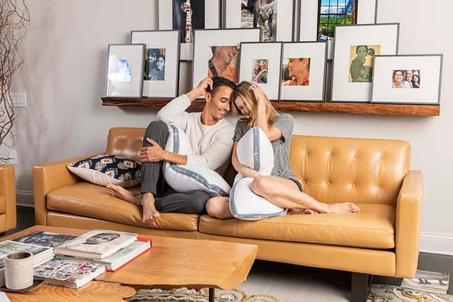 the couple on the couch holding pillows