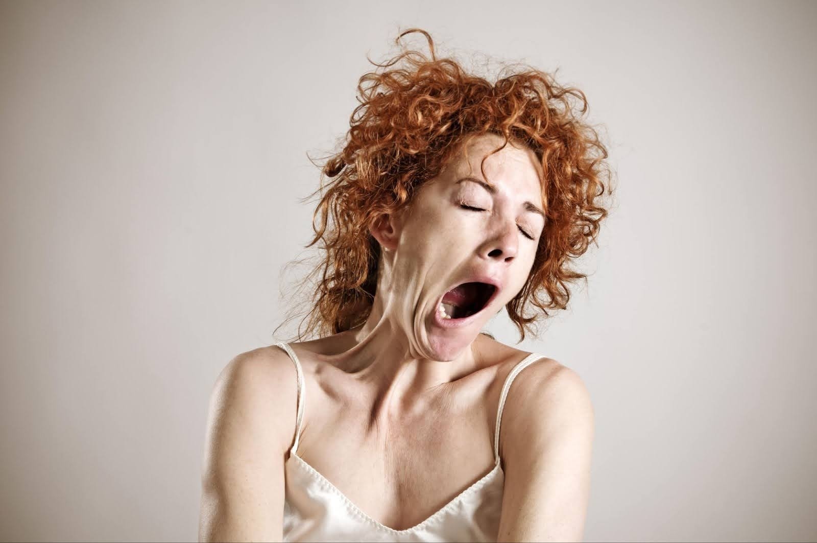 A red-haired woman yawning