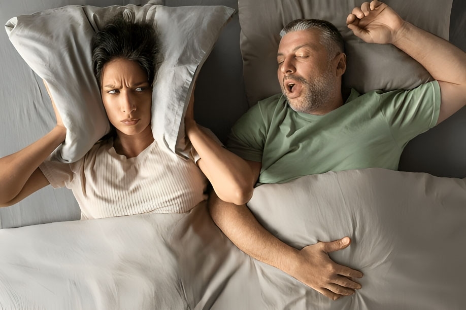 A woman unable to sleep due to his spouse's snoring noise