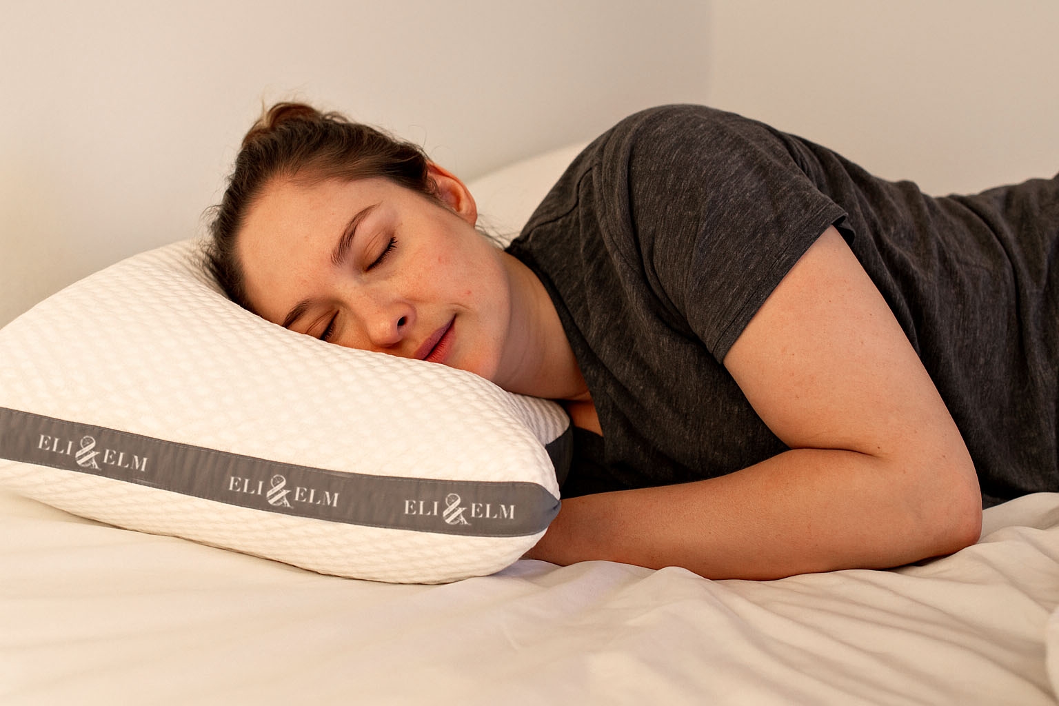 A woman sleeping comfortably on her side with a side sleeper pillow