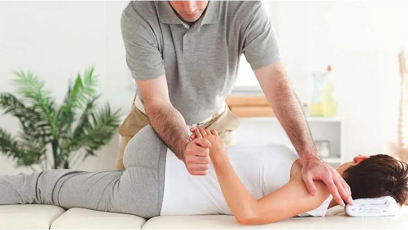 A chiropractor performing a chiropractic adjustment to a pregnant woman.