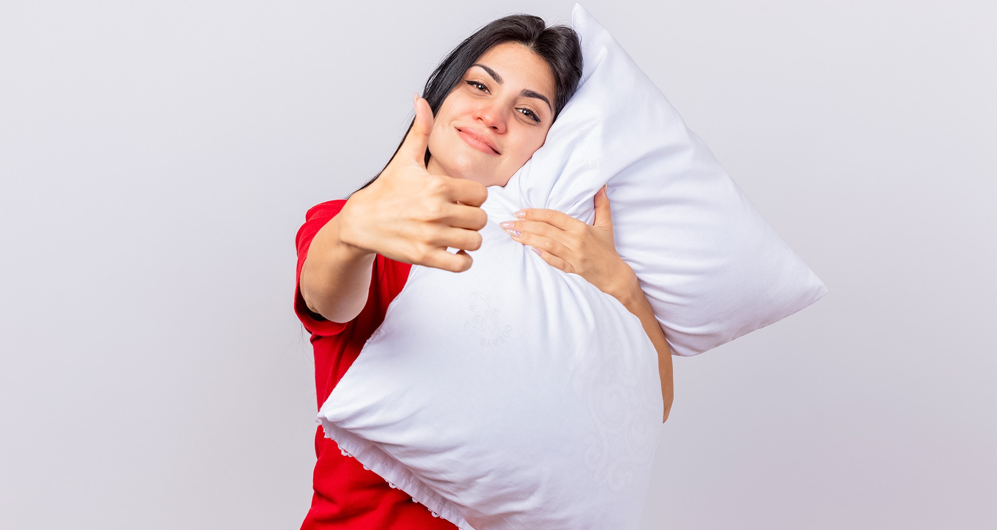 A woman posing with a white pillow.