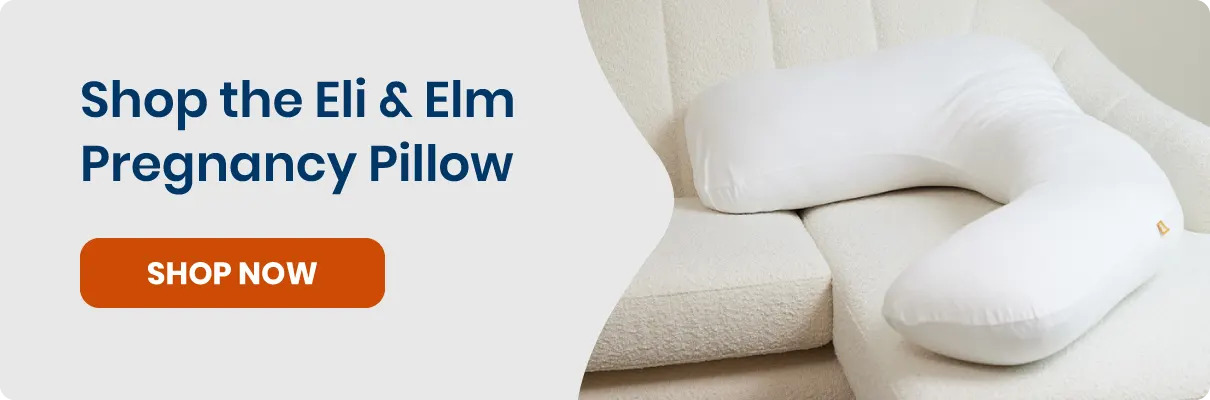 White Eli & Elm pregnancy pillow placed on a white couch